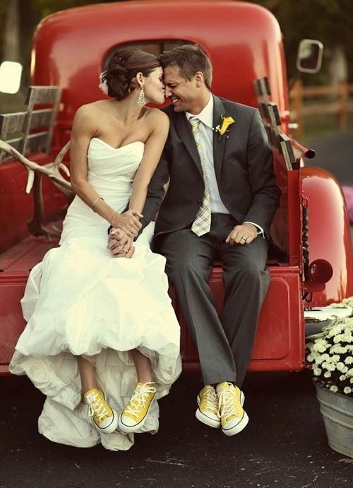 Bride and Groom kissing on back of red car with matching yellow Converses